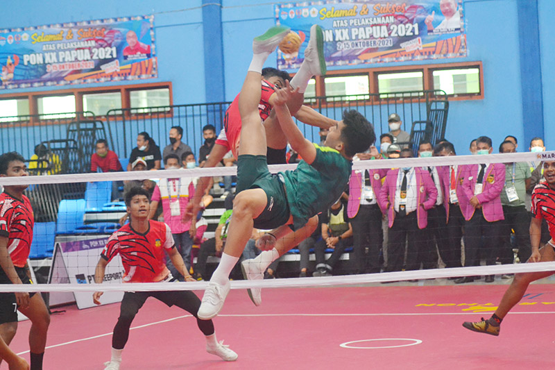 Killer Riau dan timnas Indonesia, Rizanov Kurniawan (hijau) saat melakukan smes dalam pertandingan penyisihan Grup B nomor quadrant cabang sepaktakraw PON 2021 Papua di GOR Cendrawasih, Jayapura, Kamis (7/10/2021).